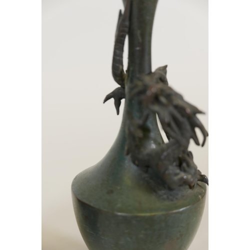 67 - A pair of Japanese patinated bronze vases with raised decoration of climbing dragons, signed, 8