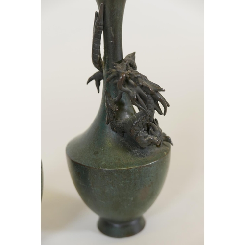 67 - A pair of Japanese patinated bronze vases with raised decoration of climbing dragons, signed, 8