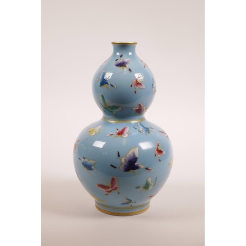 71 - A Chinese light blue ground porcelain double gourd vase with polychrome enamel butterfly decoration,... 