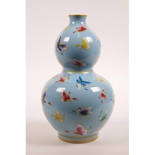 71 - A Chinese light blue ground porcelain double gourd vase with polychrome enamel butterfly decoration,... 