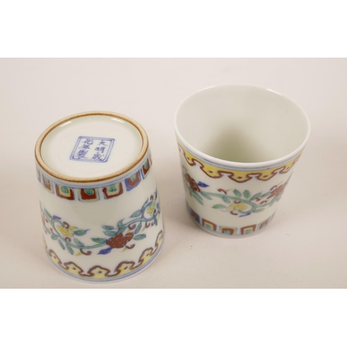 34 - A pair of Chinese doucai porcelain beakers with scrolling floral decoration, 6 character mark to bas... 