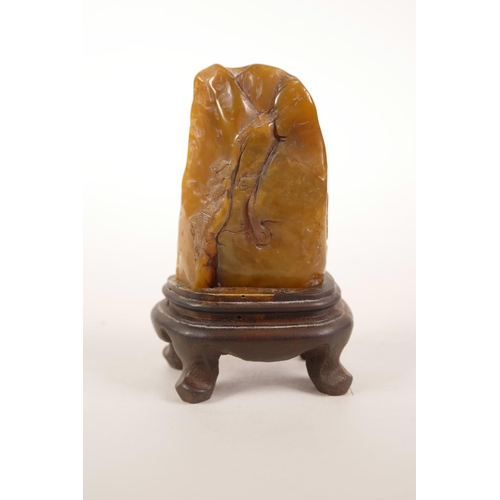 54 - A Chinese Shoushan soapstone ornament with carved decoration of figures in a landscape, mounted on a... 