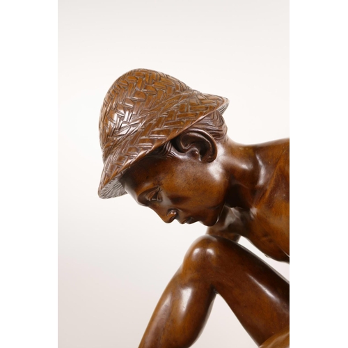 181 - An Indonesian carved hardwood sculpture of a farm worker tying a bale, 16