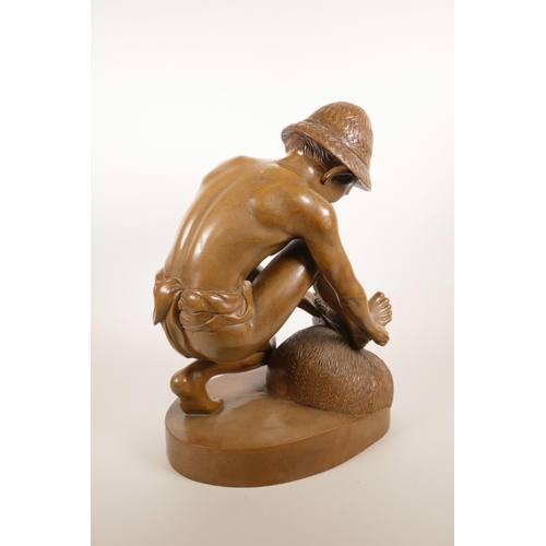 181 - An Indonesian carved hardwood sculpture of a farm worker tying a bale, 16