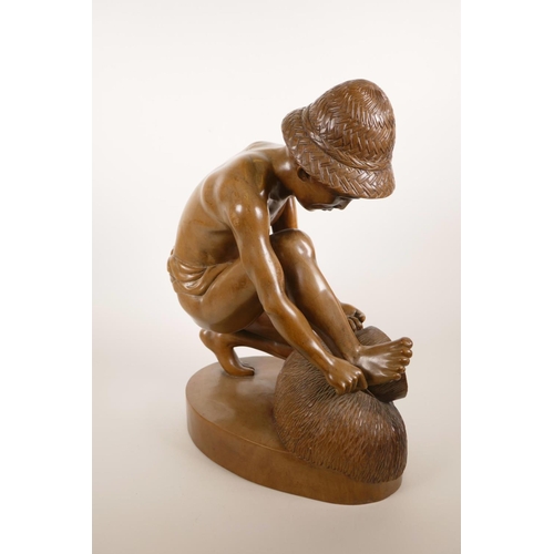 181 - An Indonesian carved hardwood sculpture of a farm worker tying a bale, 16