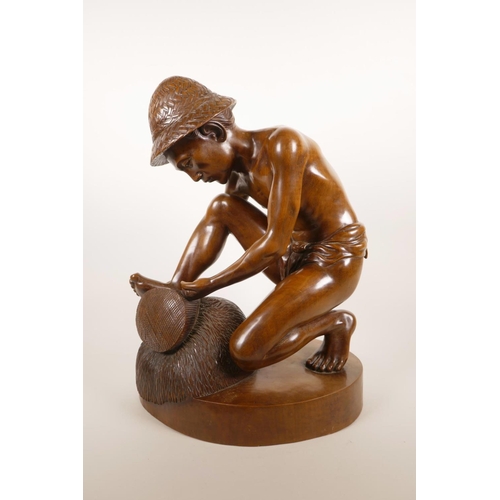 181 - An Indonesian carved hardwood sculpture of a farm worker tying a bale, 16