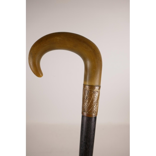 349 - A horn handled and ebonised wood walking stick with a gilt copper mount, handle possibly rhino horn,... 