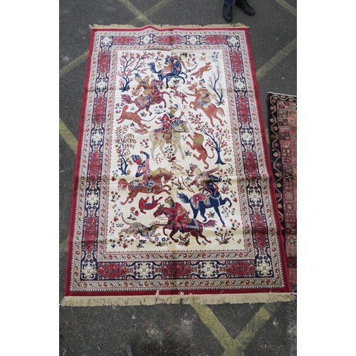 1135 - A red and ivory ground Kashmir carpet, decorated with a traditional hunting scene