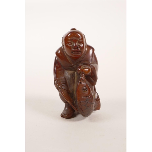 100 - A Japanese faux horn okimono carved in the form of a fisherman, 2½