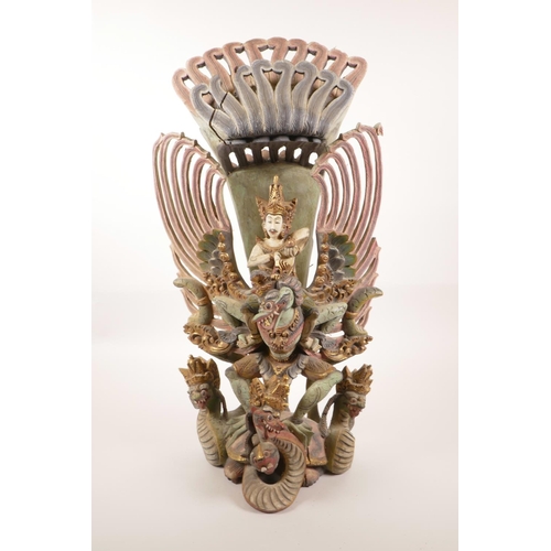 12 - A Balinese carved and painted wood figure of Vishnu riding Garuda, losses, 20½