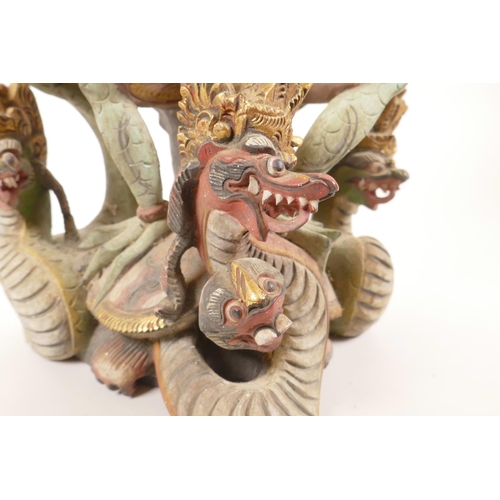 12 - A Balinese carved and painted wood figure of Vishnu riding Garuda, losses, 20½