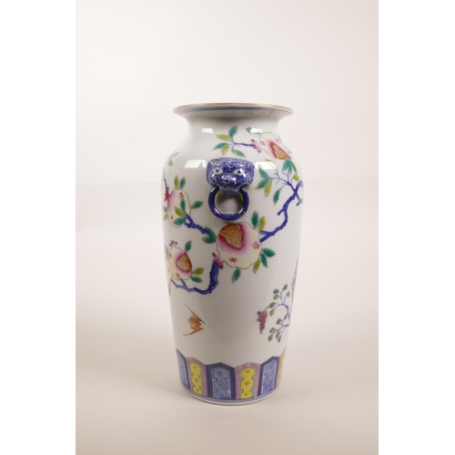 140 - A Chinese polychrome porcelain vase with two mask handles and enamelled pomegranate tree decoration,... 