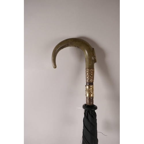 151 - A late C19th/early C20th rhino horn handled umbrella with a bamboo shaft and gilt metal mounts, 33½