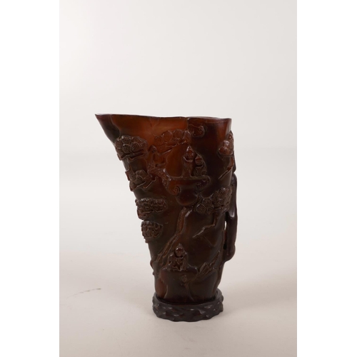 152 - A Chinese horn libation cup with carved decoration of a mountain landscape, character mark to base, ... 