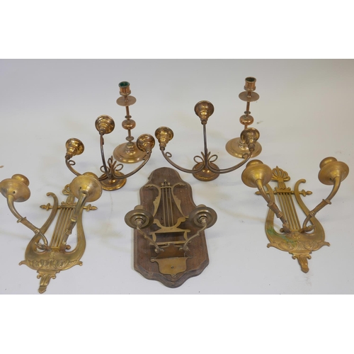 172 - Two pairs of brass candle wall sconces, together with one other and two brass candlesticks