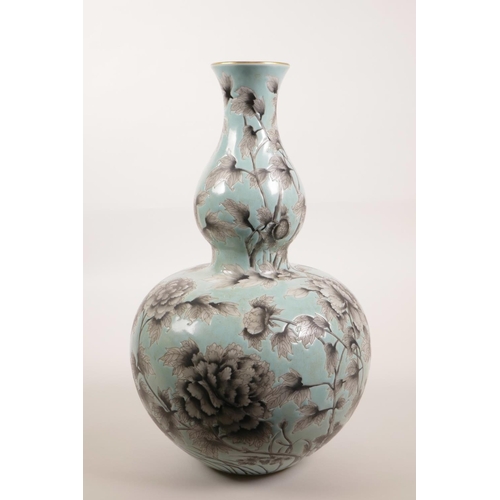 28 - A Chinese blue glazed porcelain double gourd style vase with black and white foliate decoration, 4 c... 