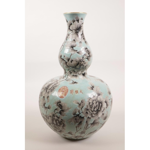 28 - A Chinese blue glazed porcelain double gourd style vase with black and white foliate decoration, 4 c... 