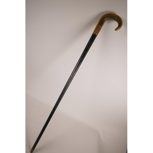 349 - A horn handled and ebonised wood walking stick with a gilt copper mount, handle possibly rhino horn,... 