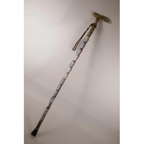 72 - A horn handled walking stick with a hallmarked silver collar, the shaft decorated with hiking badges... 