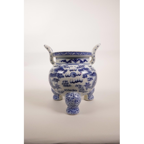 85 - A Chinese blue and white porcelain two handled censer on tripod feet, decorated with dragons chasing... 