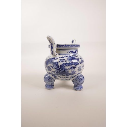 85 - A Chinese blue and white porcelain two handled censer on tripod feet, decorated with dragons chasing... 