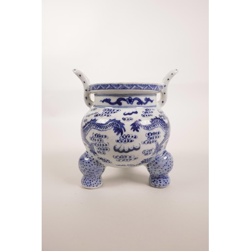 85 - A Chinese blue and white porcelain two handled censer on tripod feet, decorated with dragons chasing... 