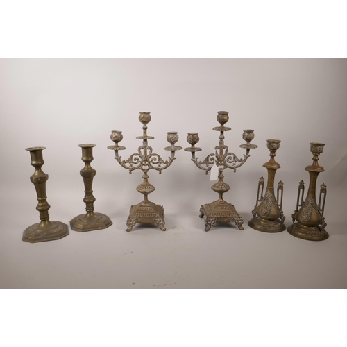 91 - A pair of bronze three branch candlesticks, together with two other pairs of candlesticks, largest 1... 