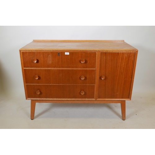 1131 - A mid C20th teak side cabinet with single cupboard and fall front drawer over two drawers, probably ... 