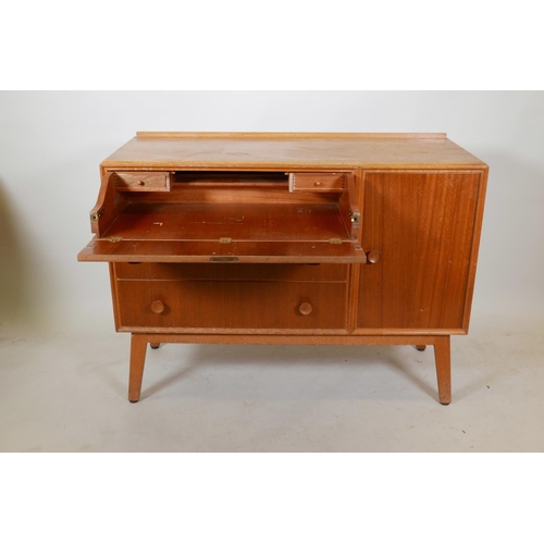 1131 - A mid C20th teak side cabinet with single cupboard and fall front drawer over two drawers, probably ... 