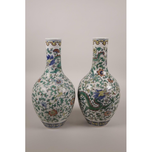 25 - A pair of Chinese doucai porcelain bottle vases decorated with dragons and flowers, seal mark to bas... 