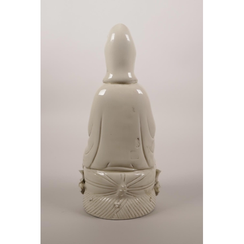 34 - A Chinese blanc de chine porcelain figure of Quan Yin seated on a lotus throne, impressed marks vers... 