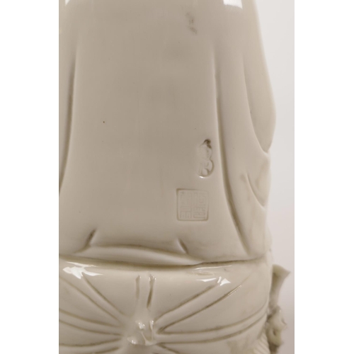 34 - A Chinese blanc de chine porcelain figure of Quan Yin seated on a lotus throne, impressed marks vers... 