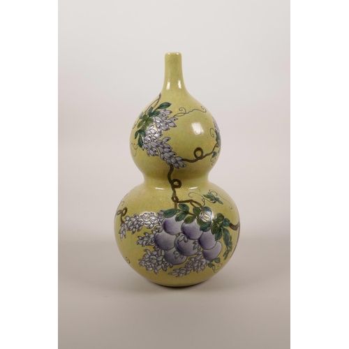 44 - A Chinese yellow ground double gourd porcelain vase with enamel decoration of a bird amongst vines a... 