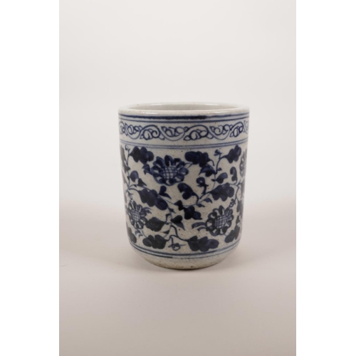 54 - A Chinese blue and white pottery brush pot with scrolling floral decoration, 4½