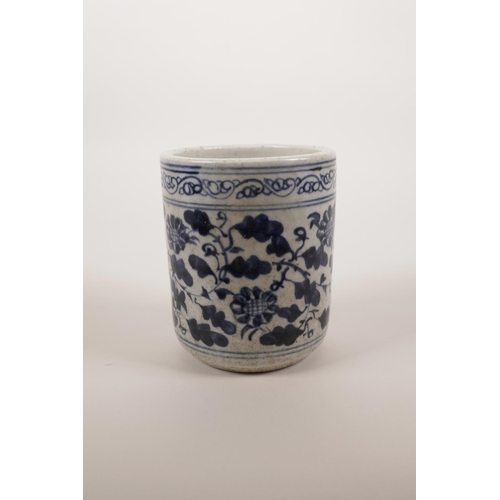 54 - A Chinese blue and white pottery brush pot with scrolling floral decoration, 4½