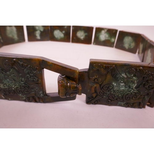 32 - A Chinese mottled hardstone belt with carved decoration of a monkey riding a horse, 39