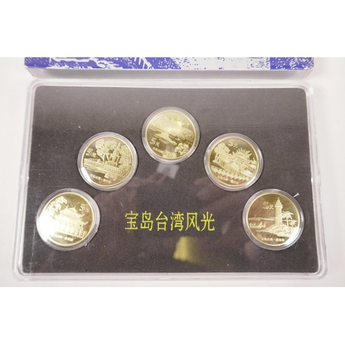 10 - A cased collection of facsimile (replica) Chinese gilt metal coins commemorating important monuments... 