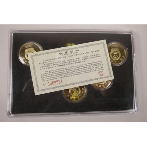 10 - A cased collection of facsimile (replica) Chinese gilt metal coins commemorating important monuments... 