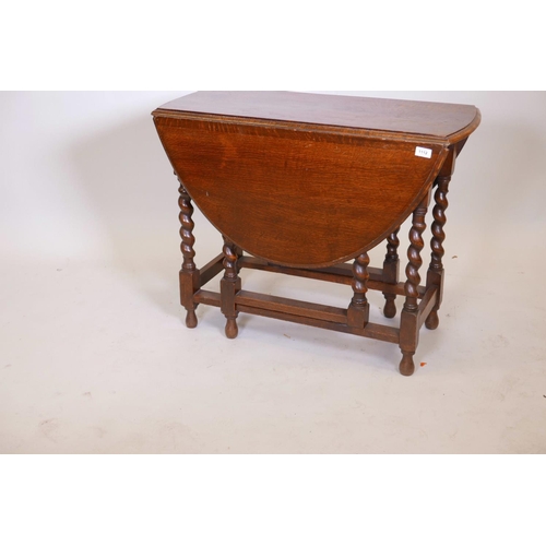 1112 - An oak drop leaf table with gateleg movement and barleytwist supports, 17