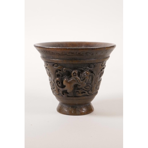 65 - A Chinese faux horn libation cup with carved kylin decoration, 4 character mark to base, 3