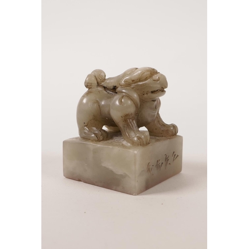 68 - A Chinese grey jade seal with a carved knop in the form of a kylin, character inscription to side, 2... 