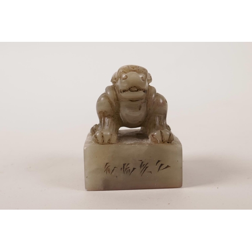 68 - A Chinese grey jade seal with a carved knop in the form of a kylin, character inscription to side, 2... 