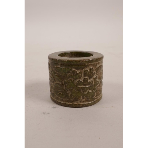 3 - A Chinese green hardstone archer's thumb ring, with carved floral decoration, 1½