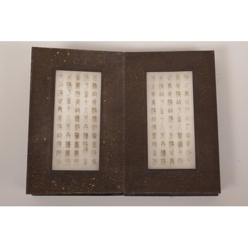 33 - A Chinese hardwood and silk bound book containing white jade tablets with engraved and gilt characte... 