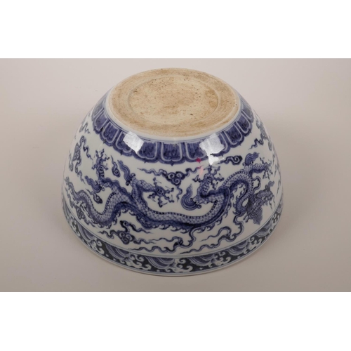 38 - A large Chinese blue and white porcelain bowl decorated with two five toed dragons in flight, 6 char... 