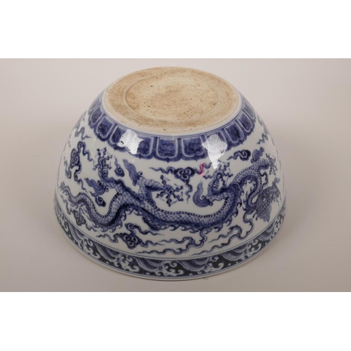 38 - A large Chinese blue and white porcelain bowl decorated with two five toed dragons in flight, 6 char... 