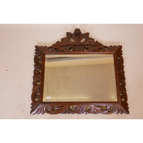 1134 - A C19th French carved oak cushion wall mirror, with original bevelled glass plate and carved lion cr... 