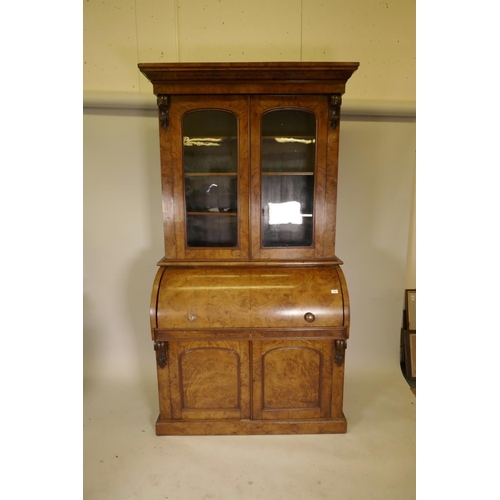 1135 - A Victorian figured and burr walnut cylinder top bureau bookcase, the upper section with arched glaz... 