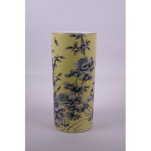 18 - A Chinese yellow ground porcelain cylinder vase with black and white decoration of Asiatic flowers, ... 