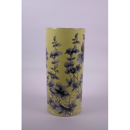 18 - A Chinese yellow ground porcelain cylinder vase with black and white decoration of Asiatic flowers, ... 